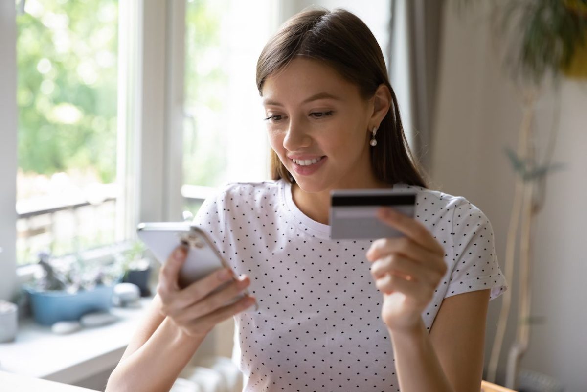 Cliente realizando el pago de la prima en un seguro desde el celular con tarjeta